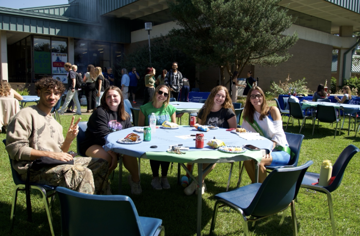 Students enjoy burgers and hot dogs at one of the tables provided during the Communications Department's Fall Kickback event on Oct. 8 outside the Communications Building.